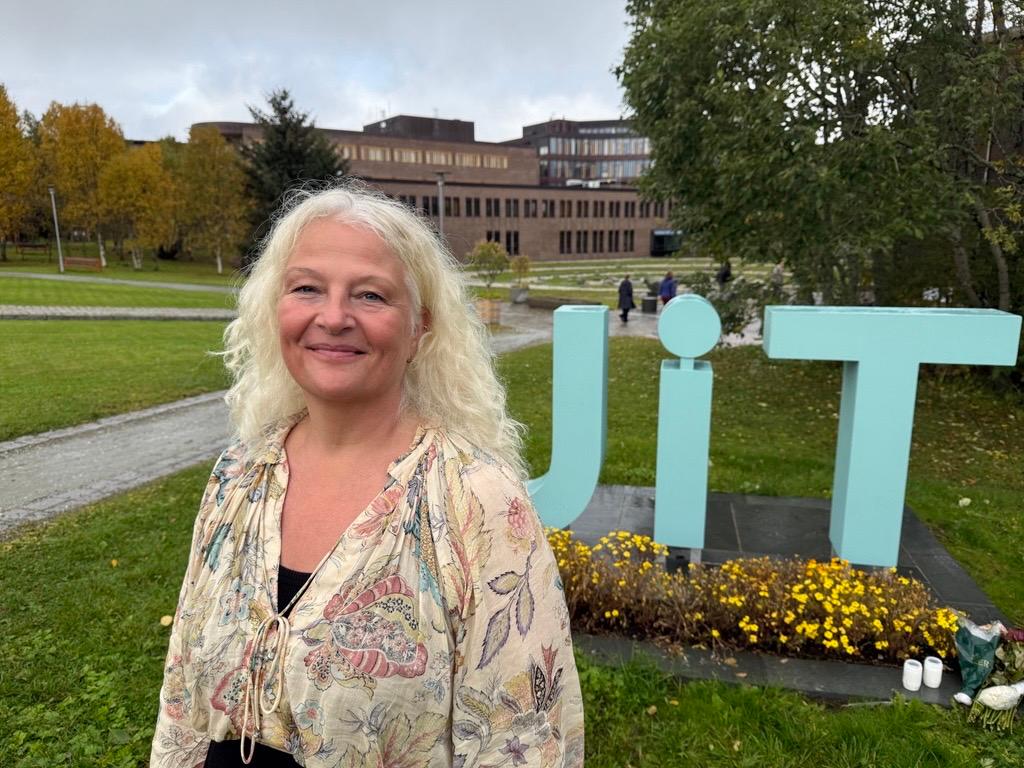 Bente Haug, portrett foran UiTs logo p&aring; campus Breivika i Troms&oslash;